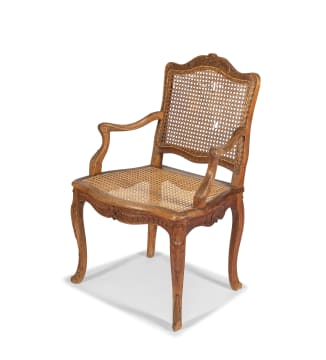 A Louis XV style carved walnut and caned armchair, 19th century