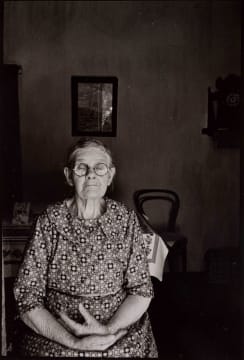 David Goldblatt; Ouma Hester Mostert, who came from Calitzdorp to Gamkaskloof as a 17-year-old bride, sitting at the door of her voorkamer. I asked if she would allow me to make a photograph of her. Would I send her a copy? she replied. I said: Yes, in about about three months' time. Don't worry. I'll be dead then, she said. The photograph was made on or about 1 January. She died on 7 April. Gamkaskloof, Cape Province (Western Cape), 1968