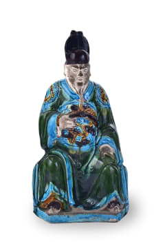 A Chinese Fehua-glazed earthenware figure of a seated official, late Ming dynasty, 1368-1644
