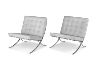 A pair of grey leather and chrome Barcelona chairs designed in 1929 by Ludwig Mies van der Rohe, later edition