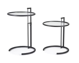 A pair of black lacquered and glass E1027 tables after a design by Eileen Gray, later edition