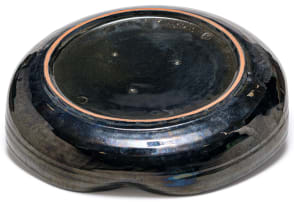 A Linn Ware iridescent blue and black-glazed petal shaped dish
