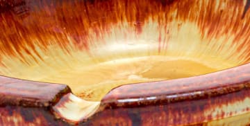 A Linn Ware cream and russet-glazed ashtray