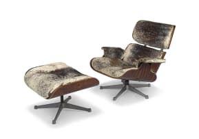 A cowhide and rosewood-veneered model 670 lounge chair and 671 ottoman released in 1956 for Herman Miller by Charles and Ray Eames, later edition