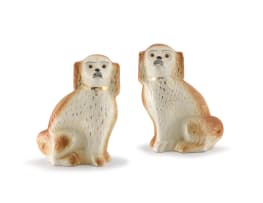 A pair of Staffordshire cream and brown-glazed dogs