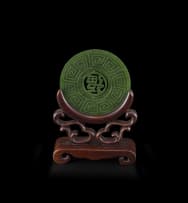 A Chinese carved spinach green jade disc, Qing Dynasty, early 20th century