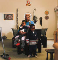 David Goldblatt; Victoria Cobokana, housekeeper, in her employers dining room with her son Sifiso and daughter Onica, Johannesburg, June 1999. Victoria died on AIDS on 13 December 1999, Sifiso died of AIDS on 12 January 2000, Onica died of AIDS in May 2000