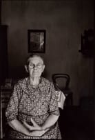 David Goldblatt; Ouma Hester Mostert, who came from Calitzdorp to Gamkaskloof as a 17-year-old bride, sitting at the door of her voorkamer. I asked if she would allow me to make a photograph of her. Would I send her a copy? she replied. I said: Yes, in about about three months' time. Don't worry. I'll be dead then, she said. The photograph was made on or about 1 January. She died on 7 April. Gamkaskloof, Cape Province (Western Cape), 1968