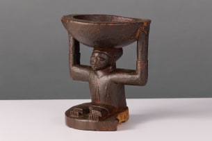 Yoruba seated figure with small offering bowl, Nigeria