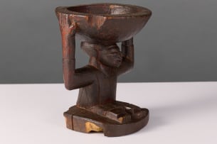 Yoruba seated figure with small offering bowl, Nigeria