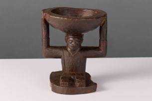 Yoruba seated figure with small offering bowl, Nigeria