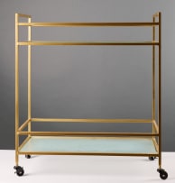 Two-tiered glass and gold-framed trolley on castors