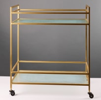 Two-tiered glass and gold-framed trolley on castors