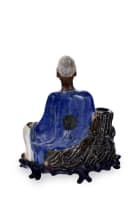 A Japanese ceramic seated figure on wooden base, late 19th or early 20th century