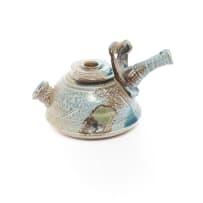 Various Artists; Wooden cabinet with glass shelves and fluorescent lights with 24 ceramic art pieces