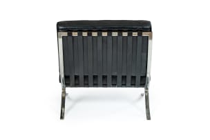 Ludwig Mies van der Rohe; Pair of black leather and chrome 'Barcelona' chairs, after a design in 1929 by Ludwig Mies van der Rohe, Italy