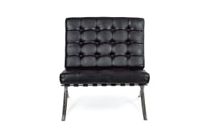 Ludwig Mies van der Rohe; Pair of black leather and chrome 'Barcelona' chairs, after a design in 1929 by Ludwig Mies van der Rohe, Italy